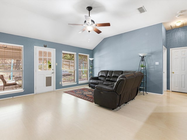 living area with baseboards, visible vents, a ceiling fan, lofted ceiling, and light wood-style flooring