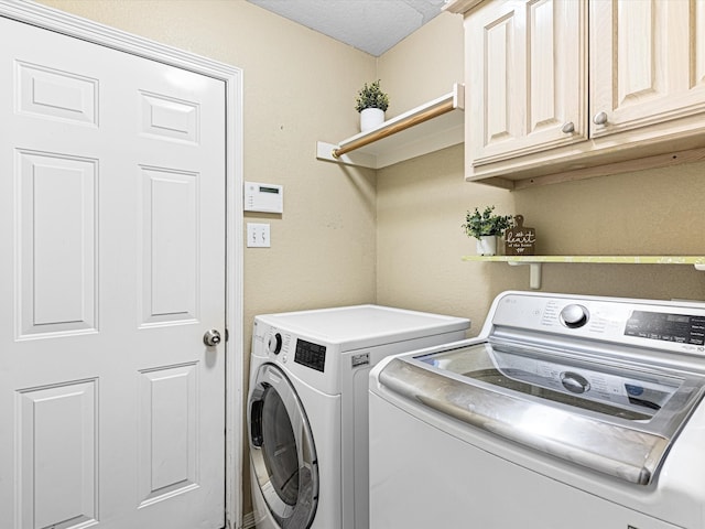 washroom featuring independent washer and dryer, a textured ceiling, and cabinets