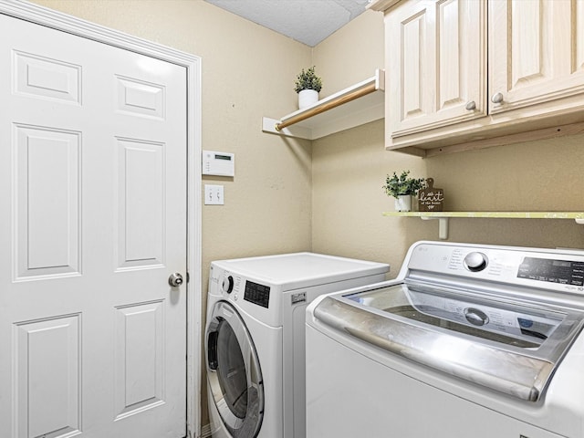 laundry room with washer and dryer, cabinet space, and a textured ceiling