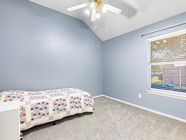 carpeted bedroom with baseboards, vaulted ceiling, a ceiling fan, and a textured wall