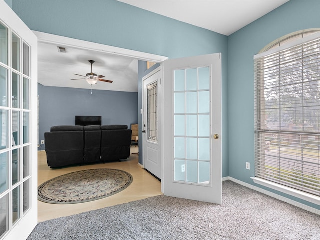 carpeted foyer with french doors, ceiling fan, and plenty of natural light