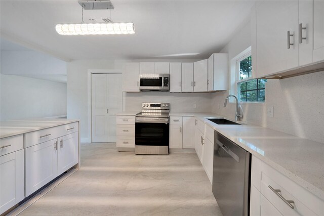 kitchen with appliances with stainless steel finishes, light hardwood / wood-style flooring, sink, and white cabinets