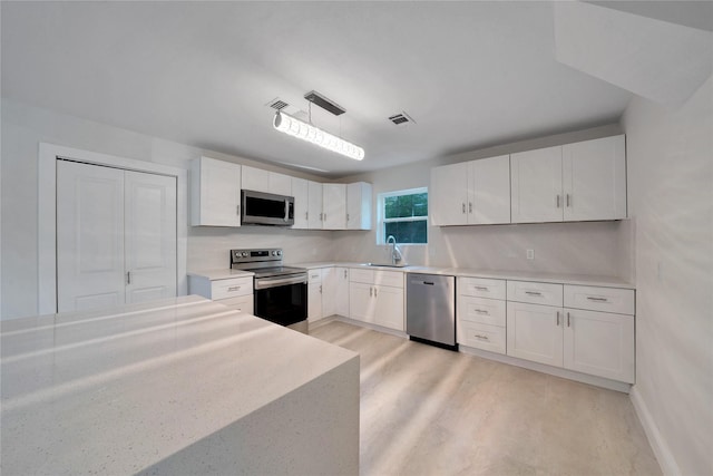 kitchen featuring a sink, visible vents, white cabinetry, light countertops, and appliances with stainless steel finishes