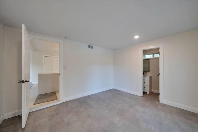 unfurnished bedroom featuring light tile patterned floors and ensuite bathroom