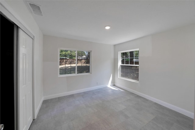 spare room featuring baseboards, visible vents, and recessed lighting