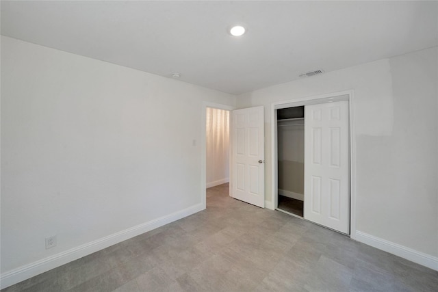 unfurnished bedroom featuring light floors, a closet, visible vents, and baseboards