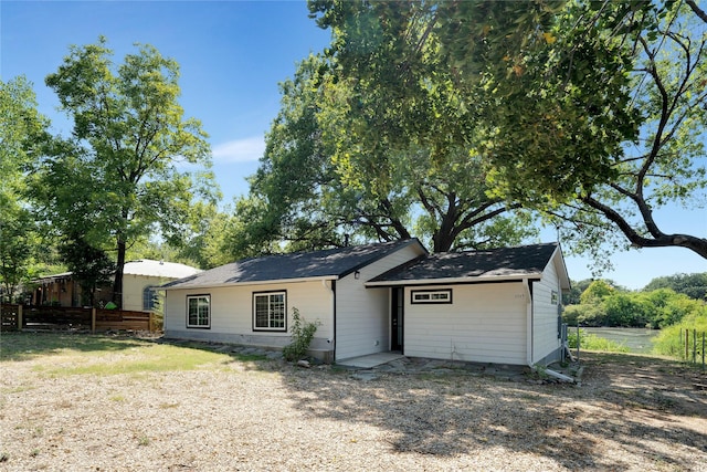 ranch-style home featuring fence