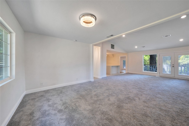 unfurnished living room with french doors, lofted ceiling, and carpet