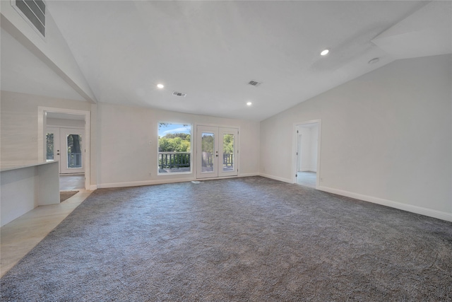 unfurnished living room with light carpet, french doors, and lofted ceiling