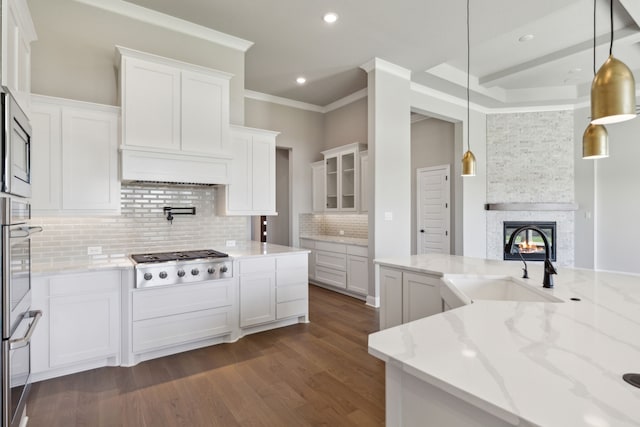 kitchen with white cabinetry, light stone counters, decorative light fixtures, and appliances with stainless steel finishes