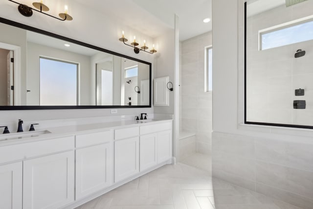 bathroom with vanity, a healthy amount of sunlight, and a tile shower