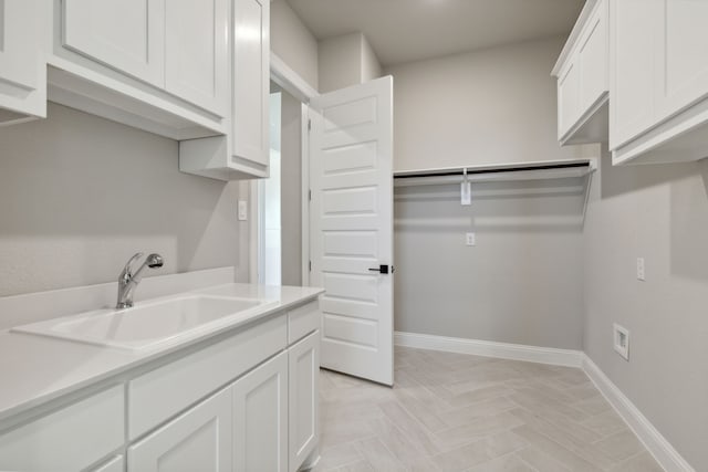 clothes washing area featuring hookup for a washing machine, sink, cabinets, and hookup for an electric dryer