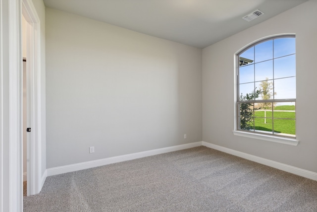 carpeted empty room featuring visible vents and baseboards