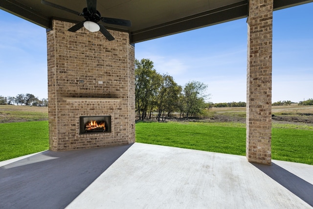 view of patio / terrace with a rural view, an outdoor brick fireplace, and ceiling fan