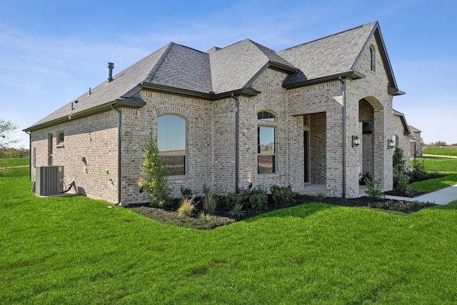 view of property exterior featuring central air condition unit and a lawn