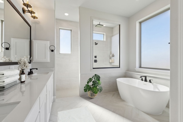 full bathroom with double vanity, a freestanding bath, a sink, a walk in shower, and tile patterned flooring