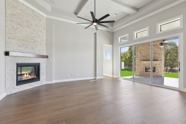 unfurnished living room with hardwood / wood-style floors, ceiling fan, a fireplace, and a wealth of natural light