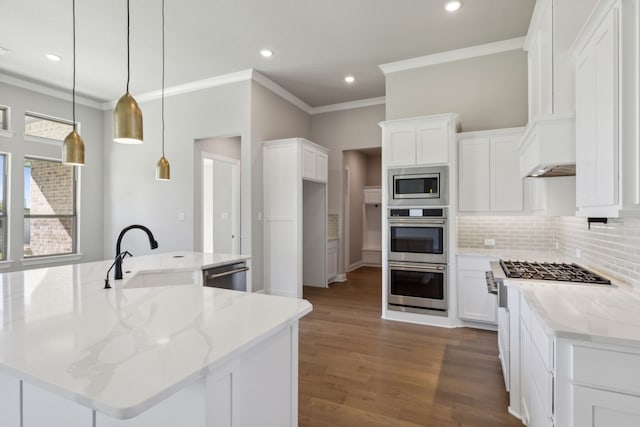 kitchen with pendant lighting, white cabinets, a center island with sink, sink, and light stone counters