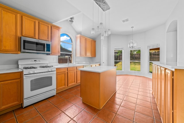 kitchen featuring an inviting chandelier, stove, pendant lighting, and a kitchen island