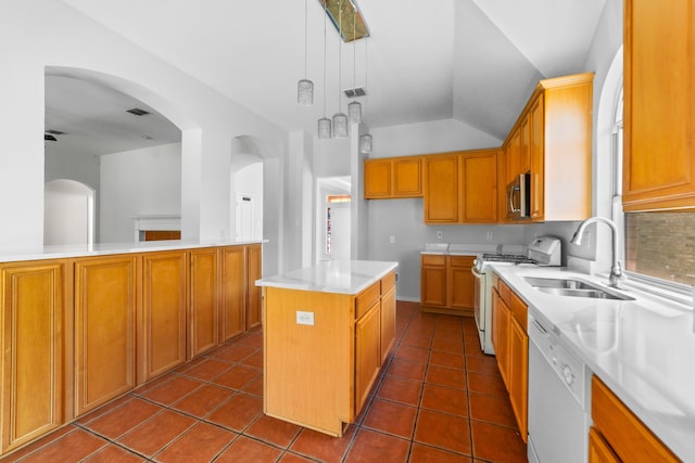 kitchen featuring pendant lighting, sink, dark tile patterned flooring, a center island, and white appliances