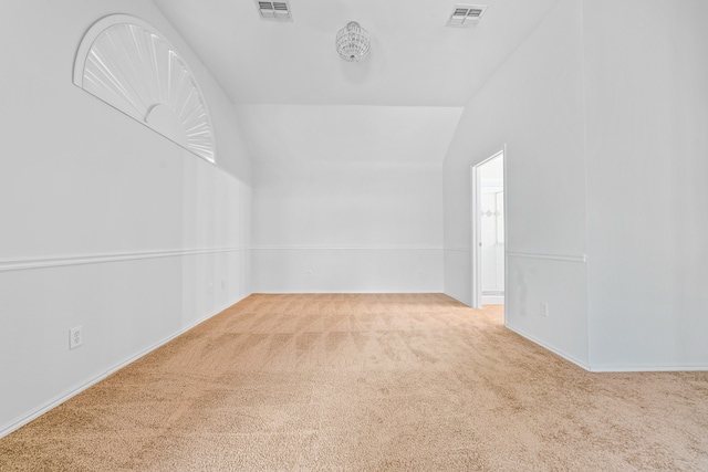 carpeted spare room featuring vaulted ceiling