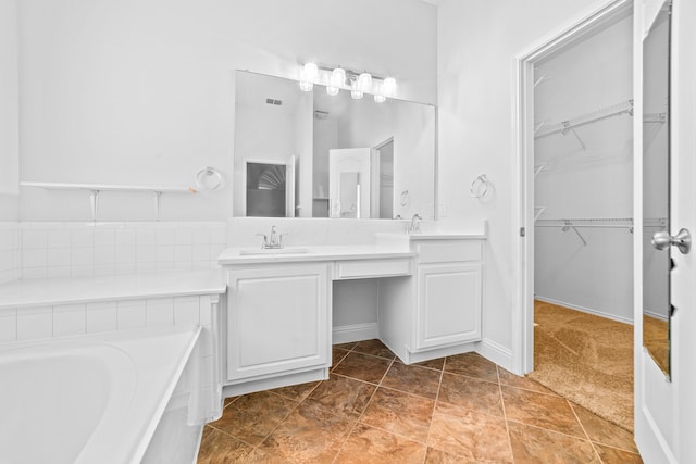 bathroom with tile patterned flooring, a tub to relax in, and vanity