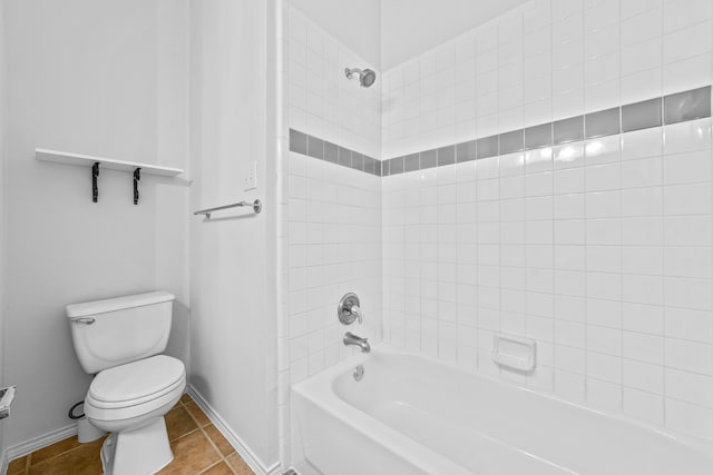 bathroom with tiled shower / bath combo, toilet, and tile patterned flooring