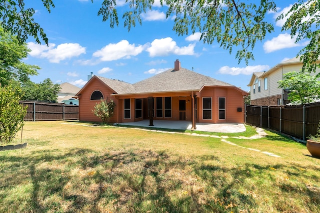 back of house with a patio and a lawn