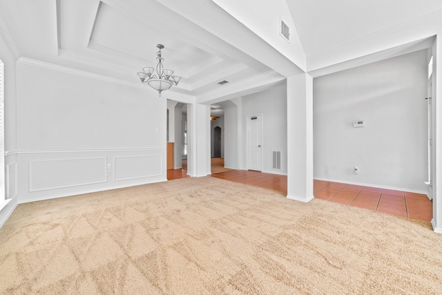 unfurnished living room with a raised ceiling, an inviting chandelier, ornamental molding, and tile patterned floors