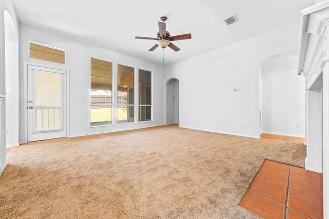 unfurnished living room featuring ceiling fan and carpet