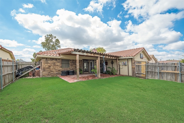 back of house featuring a lawn and a patio area