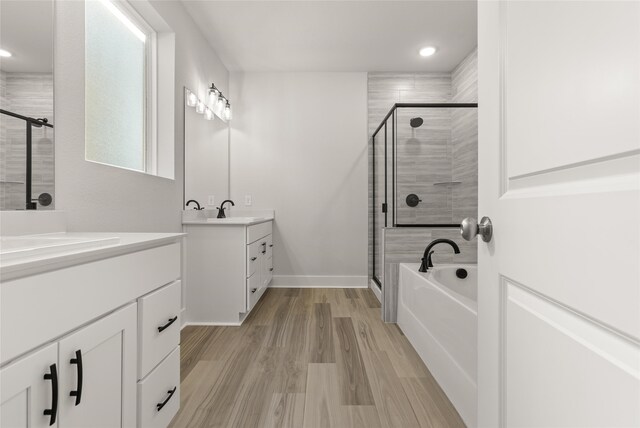 bathroom with vanity, hardwood / wood-style floors, and plus walk in shower