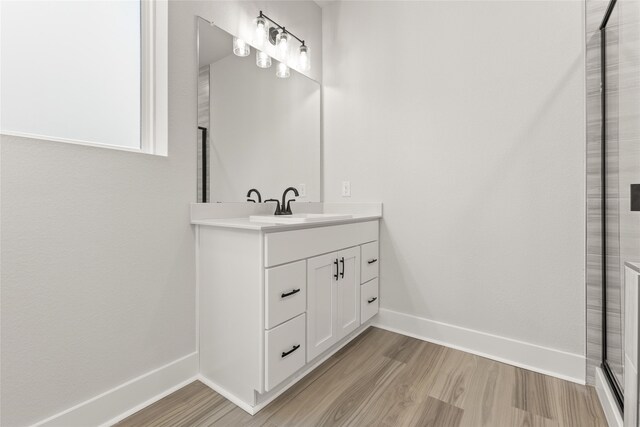 bathroom with vanity, an enclosed shower, and hardwood / wood-style floors