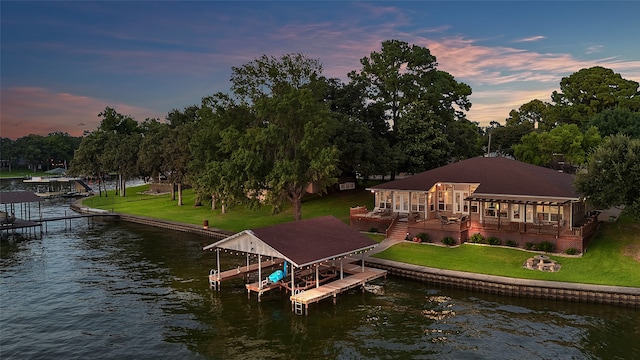 view of dock featuring a lawn and a water view