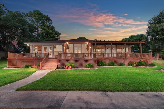 view of front of property with a wooden deck and a yard