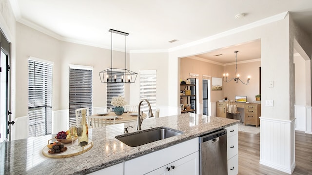 kitchen featuring white cabinets, sink, decorative light fixtures, and light stone countertops