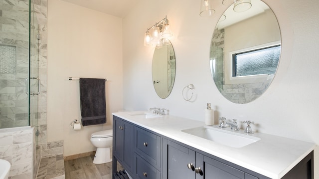 bathroom featuring hardwood / wood-style floors, a shower with door, vanity, and toilet