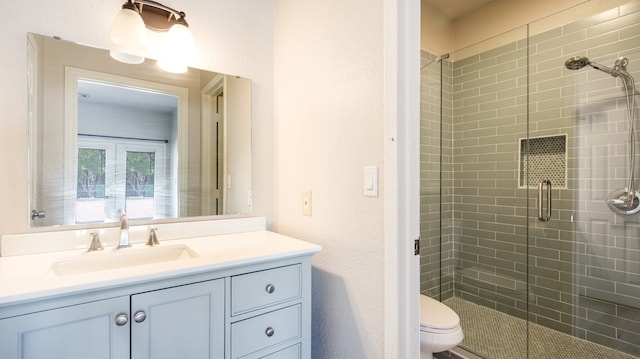 bathroom with vanity, toilet, and an enclosed shower