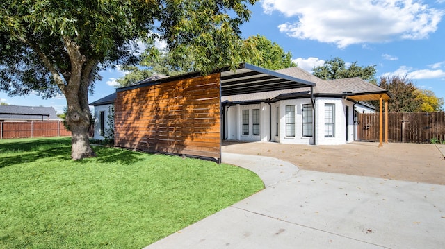 view of front of property with a front lawn, a patio, and french doors