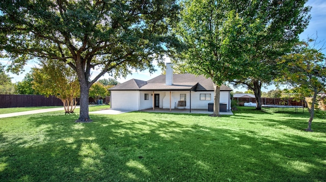 ranch-style home featuring a front yard, a patio, and a trampoline