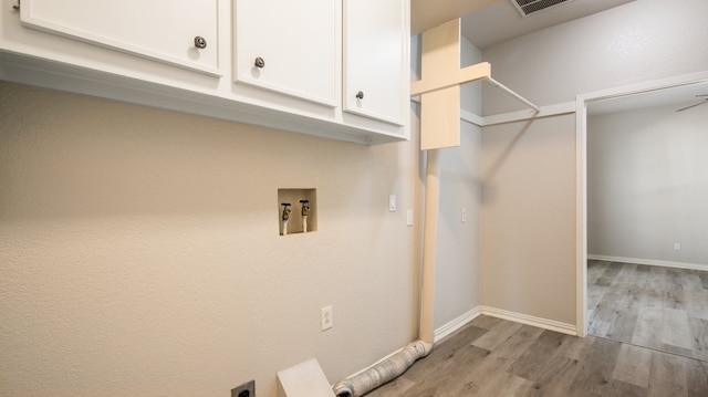 laundry area with light hardwood / wood-style floors, electric dryer hookup, cabinets, and washer hookup