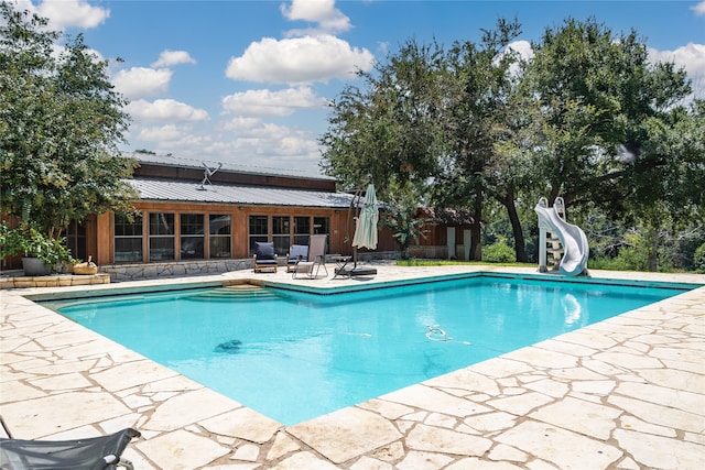 view of swimming pool featuring a patio and a water slide