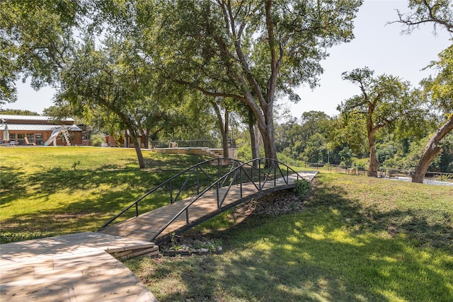 view of property's community with a yard and a pergola