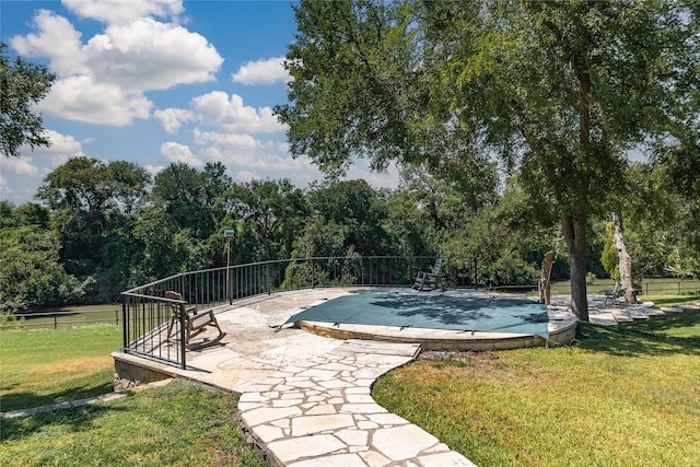 view of pool featuring a lawn