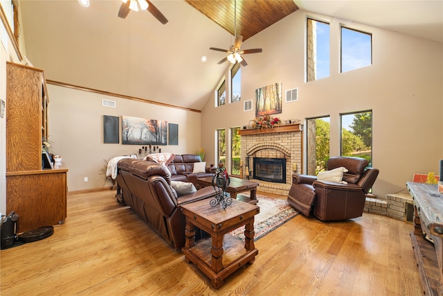 living room featuring a fireplace, light hardwood / wood-style flooring, ceiling fan, and high vaulted ceiling