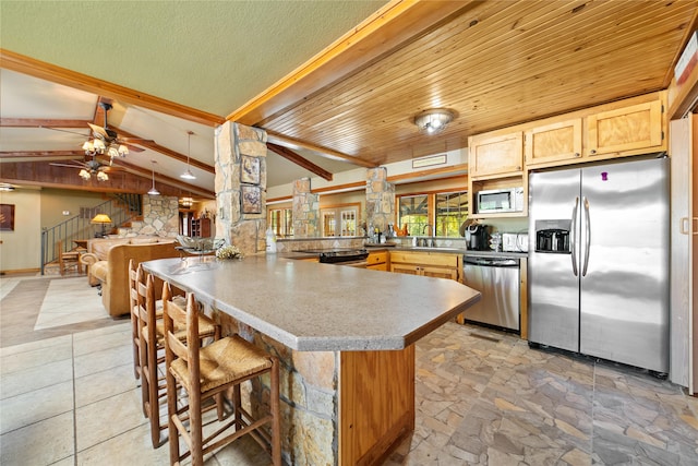 kitchen featuring stainless steel appliances, sink, vaulted ceiling with beams, kitchen peninsula, and ceiling fan