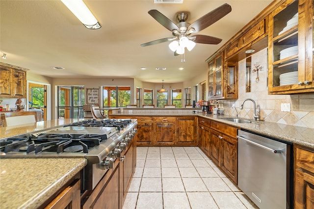 kitchen featuring sink, light tile patterned floors, decorative backsplash, dishwasher, and ceiling fan