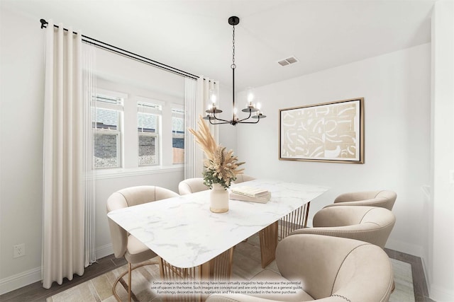 dining area featuring hardwood / wood-style flooring and an inviting chandelier