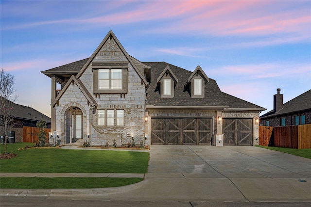 view of front of house featuring a garage and a lawn