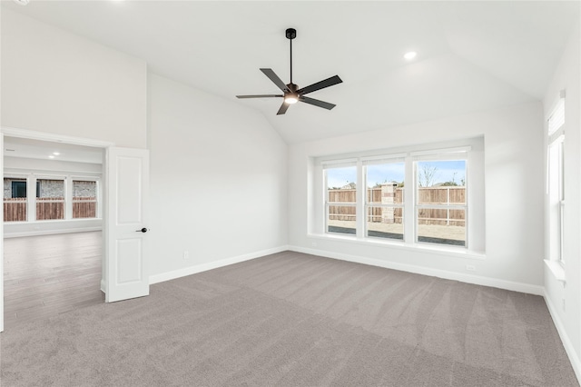 carpeted empty room featuring ceiling fan and vaulted ceiling